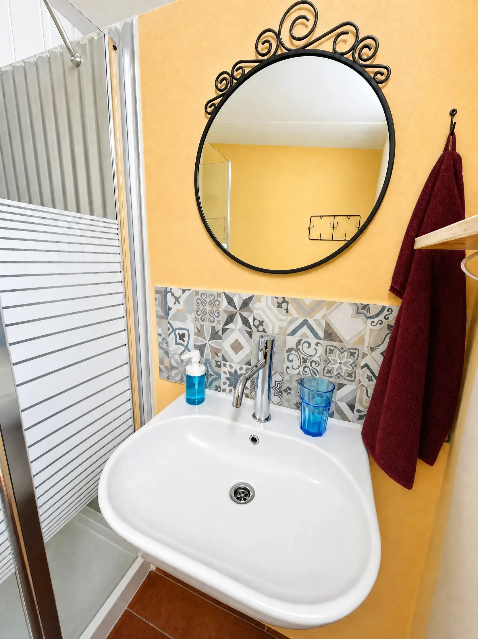 A white sink and an ornate mirror
