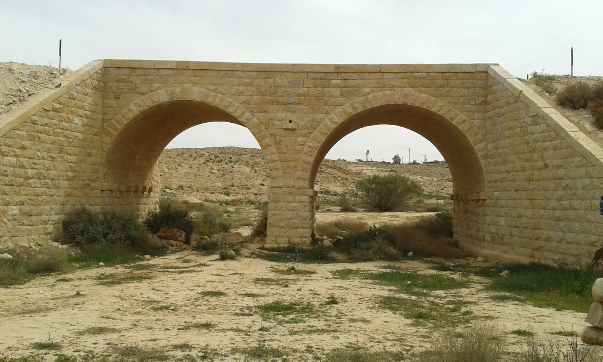גשר אבן בעל שתי קשתות מעל ערוץ נחל יבש ליד עזוז