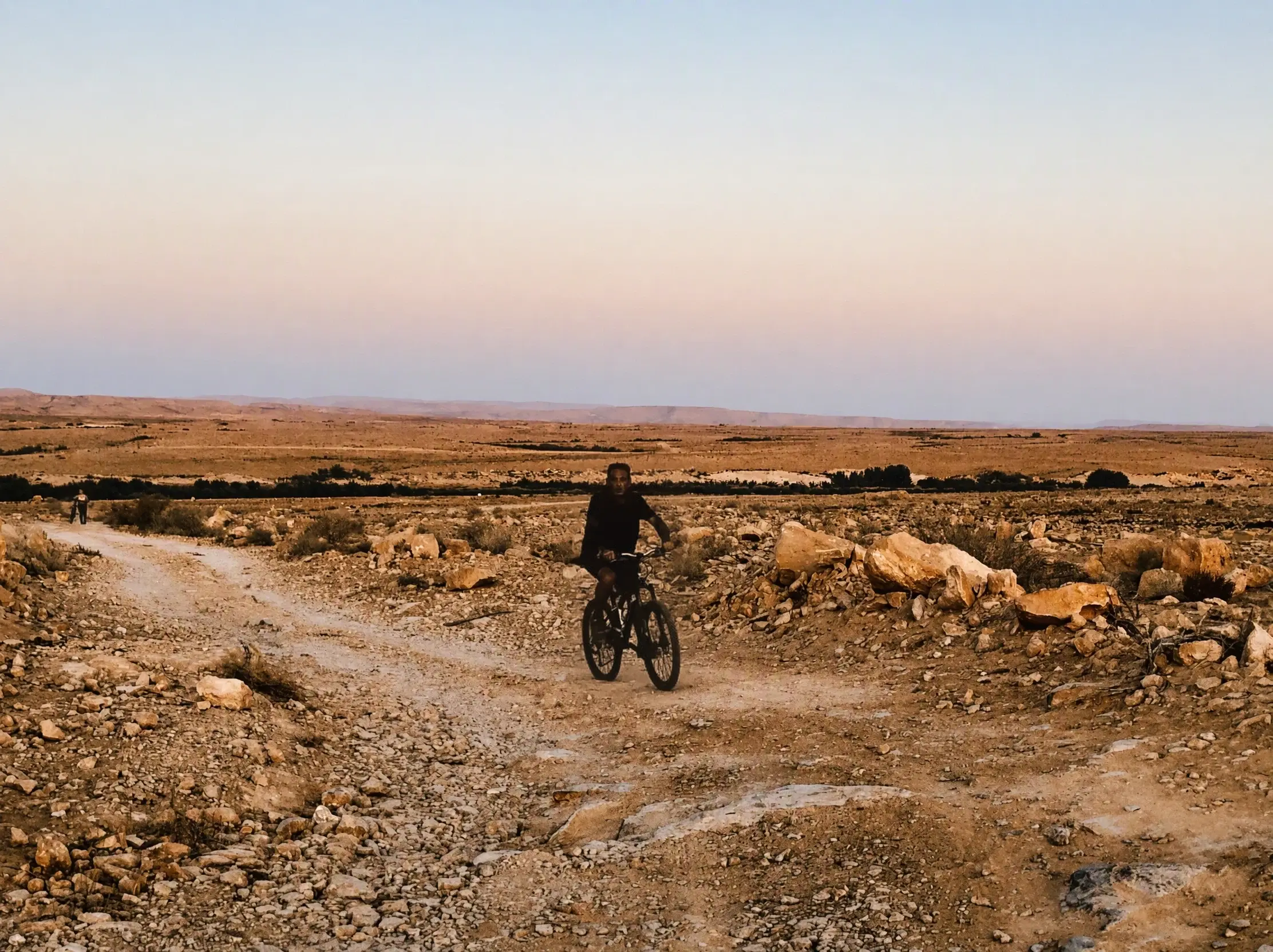A cyclist on a desert trail in the evening