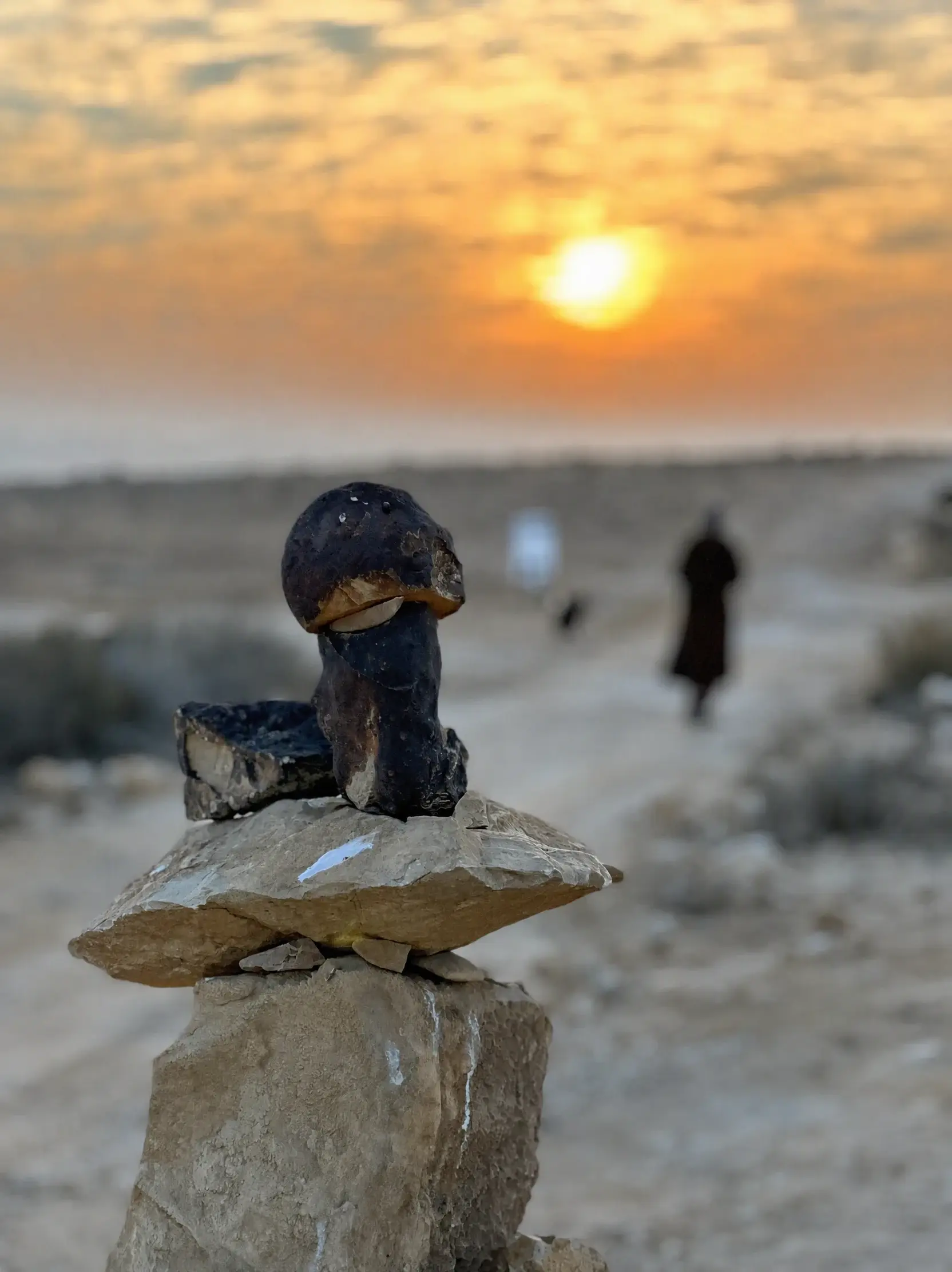 A small sculpture on a rock at sunset