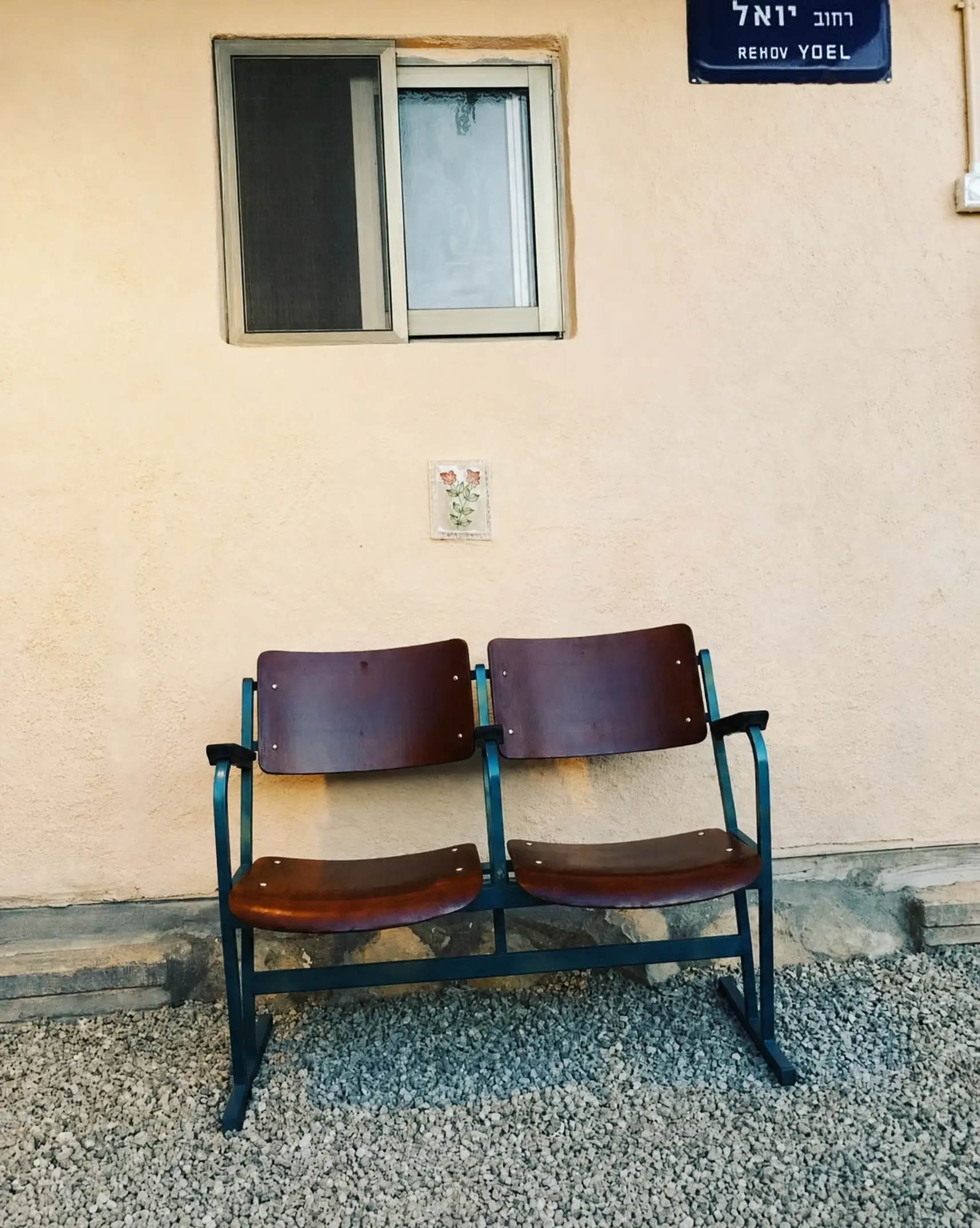 A pair of old cinema seats under a window