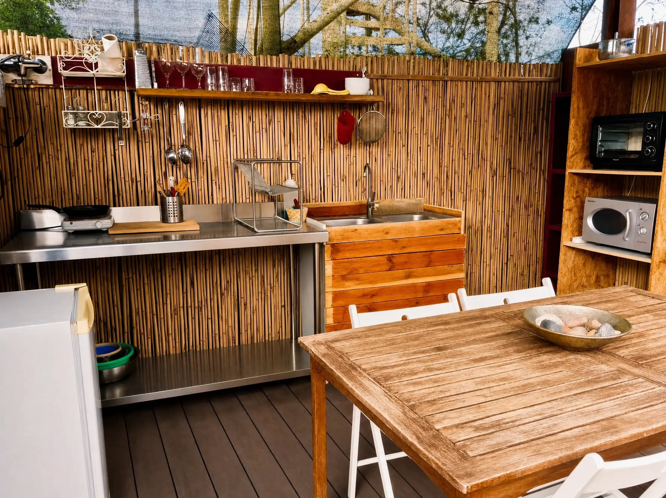 A wooden kitchen with a bamboo wall and a dining table