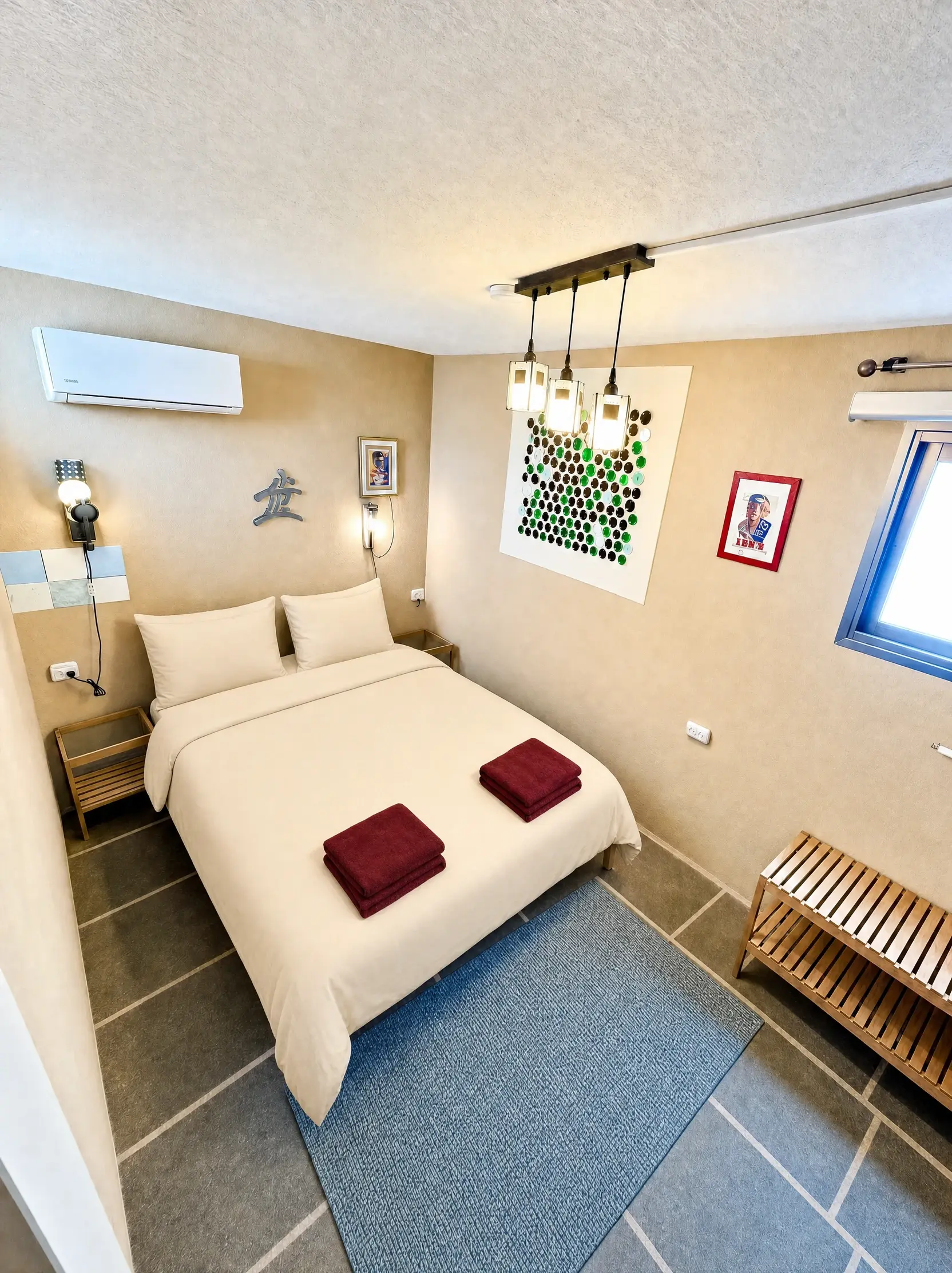 The Maayan room: a double bed, hanging bottle lamps and a stained-glass window