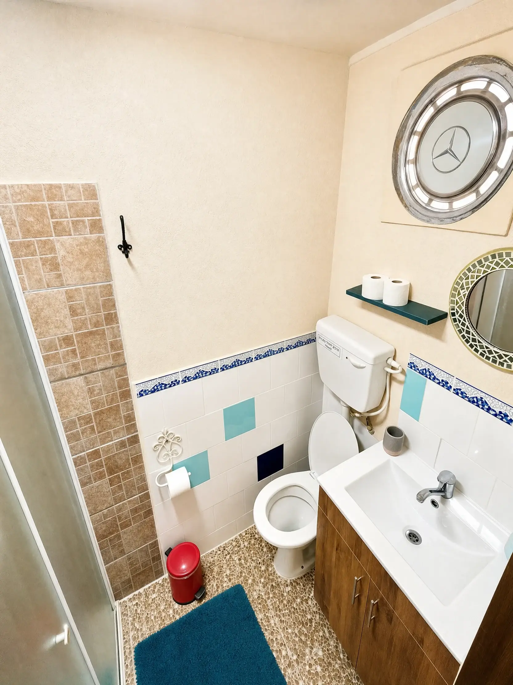 The Muse bathroom, with a round mirror and blue tiles