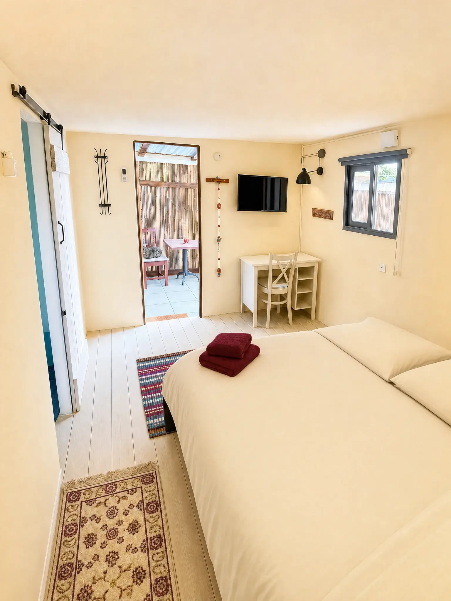 The Raz room from the corner: the double bed, a desk and the patio door