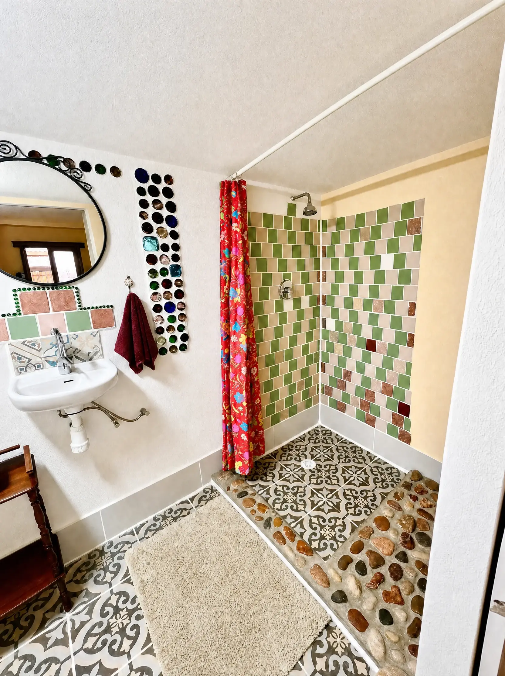 The Raz shower: green tiles, a red floral curtain and a river-stone floor