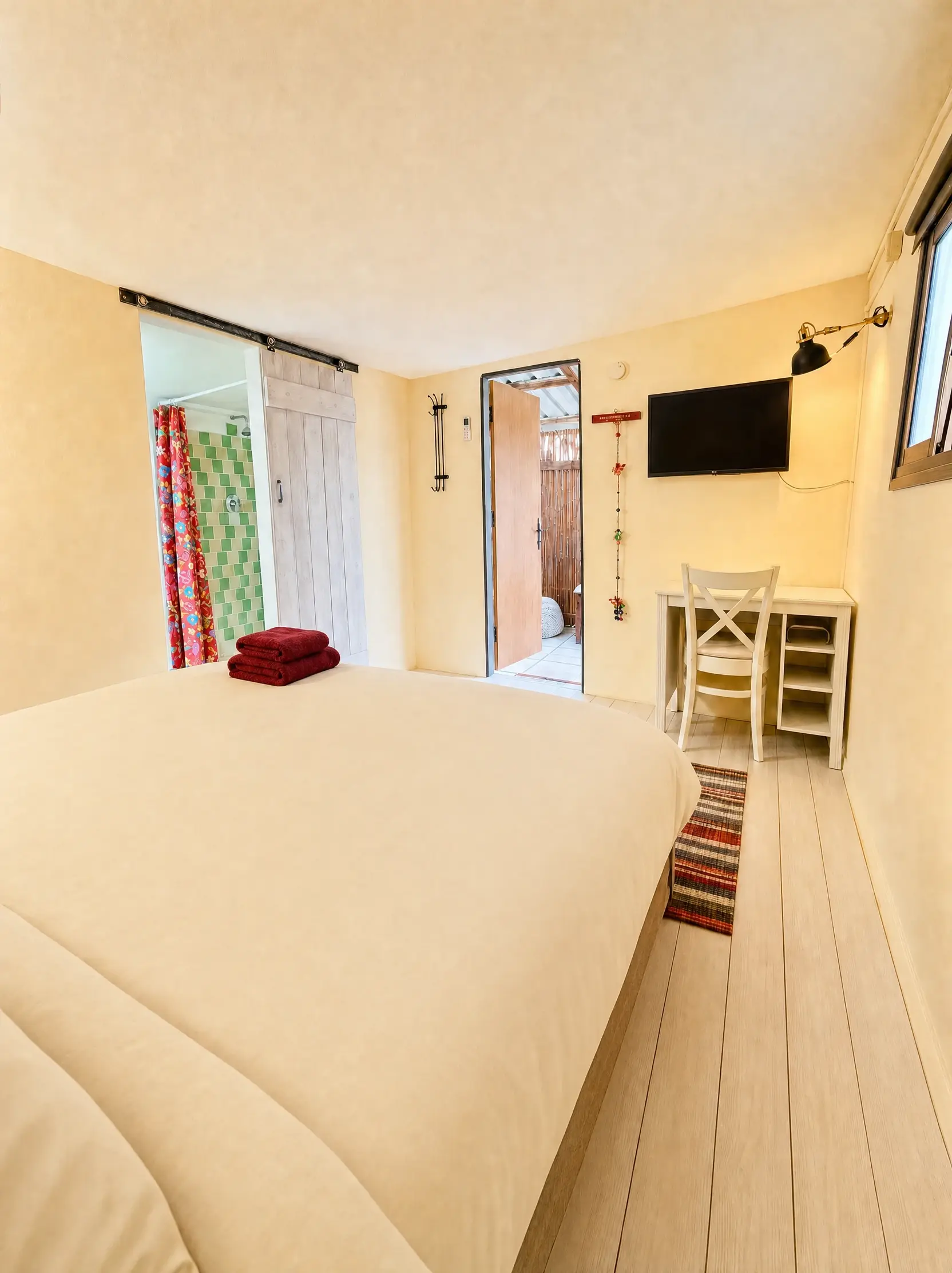 The Raz room: the bed, a sliding door to the bathroom and the door open to the patio