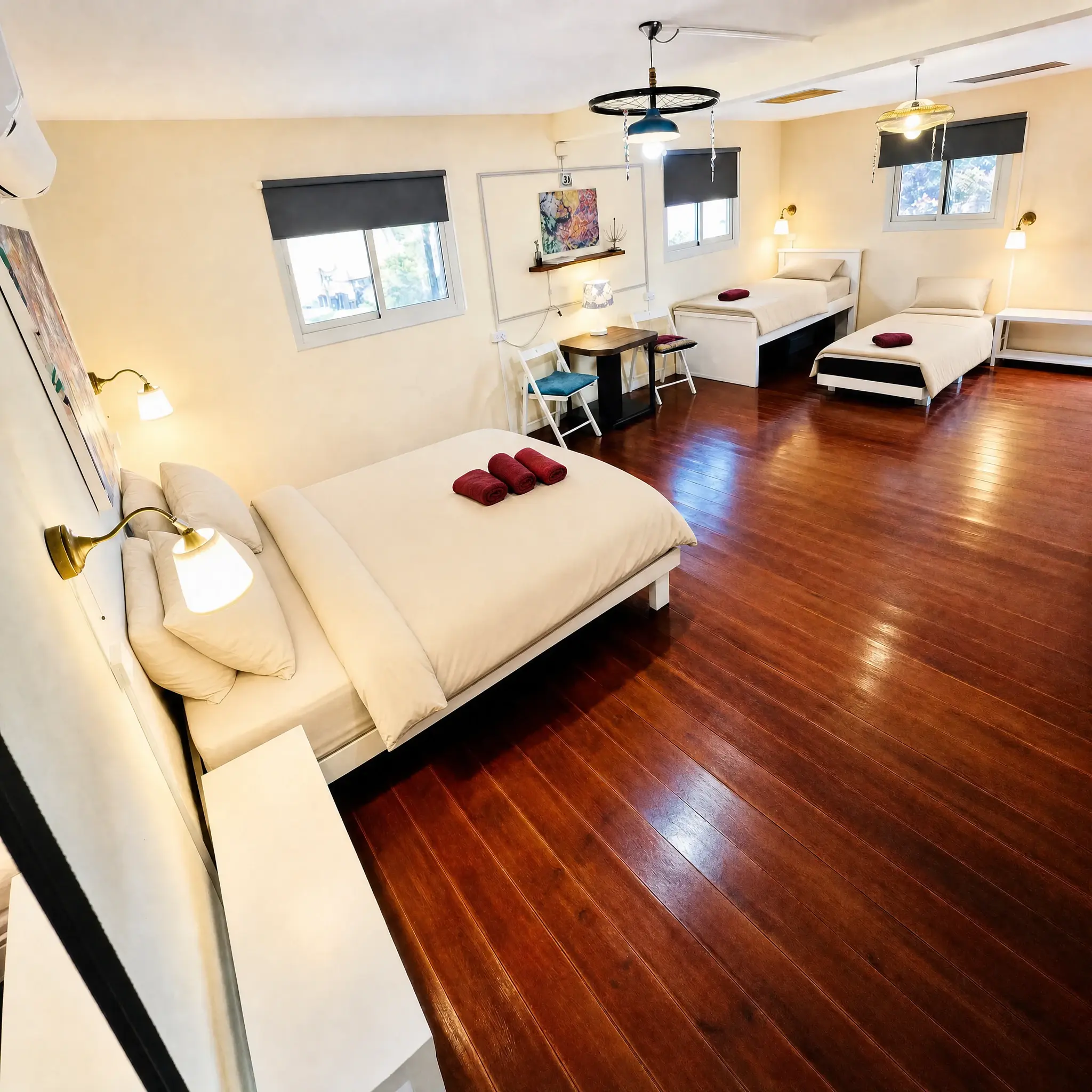 The Studio: a large room with a wooden floor and single beds