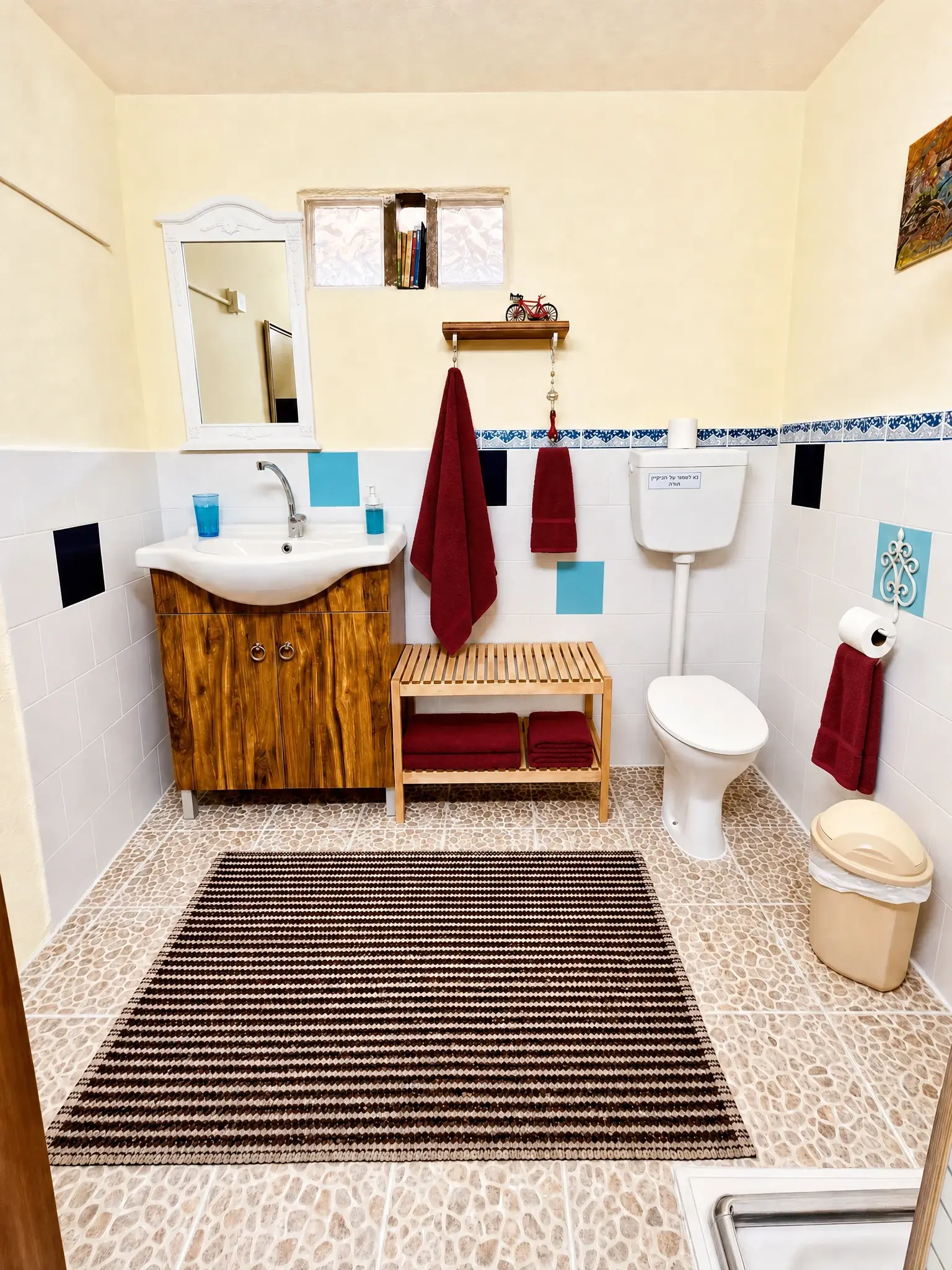 The Studio bathroom: a wooden vanity, a mirror and a rug