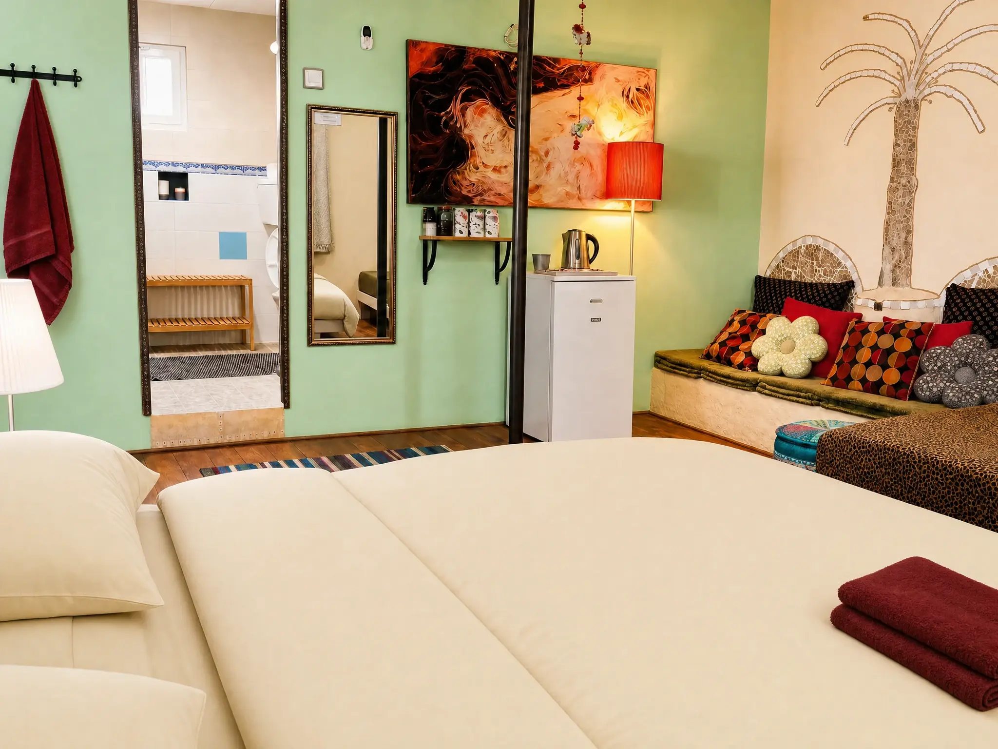 A corner of the Triple room: a green wall, a mirror and a cushioned bench