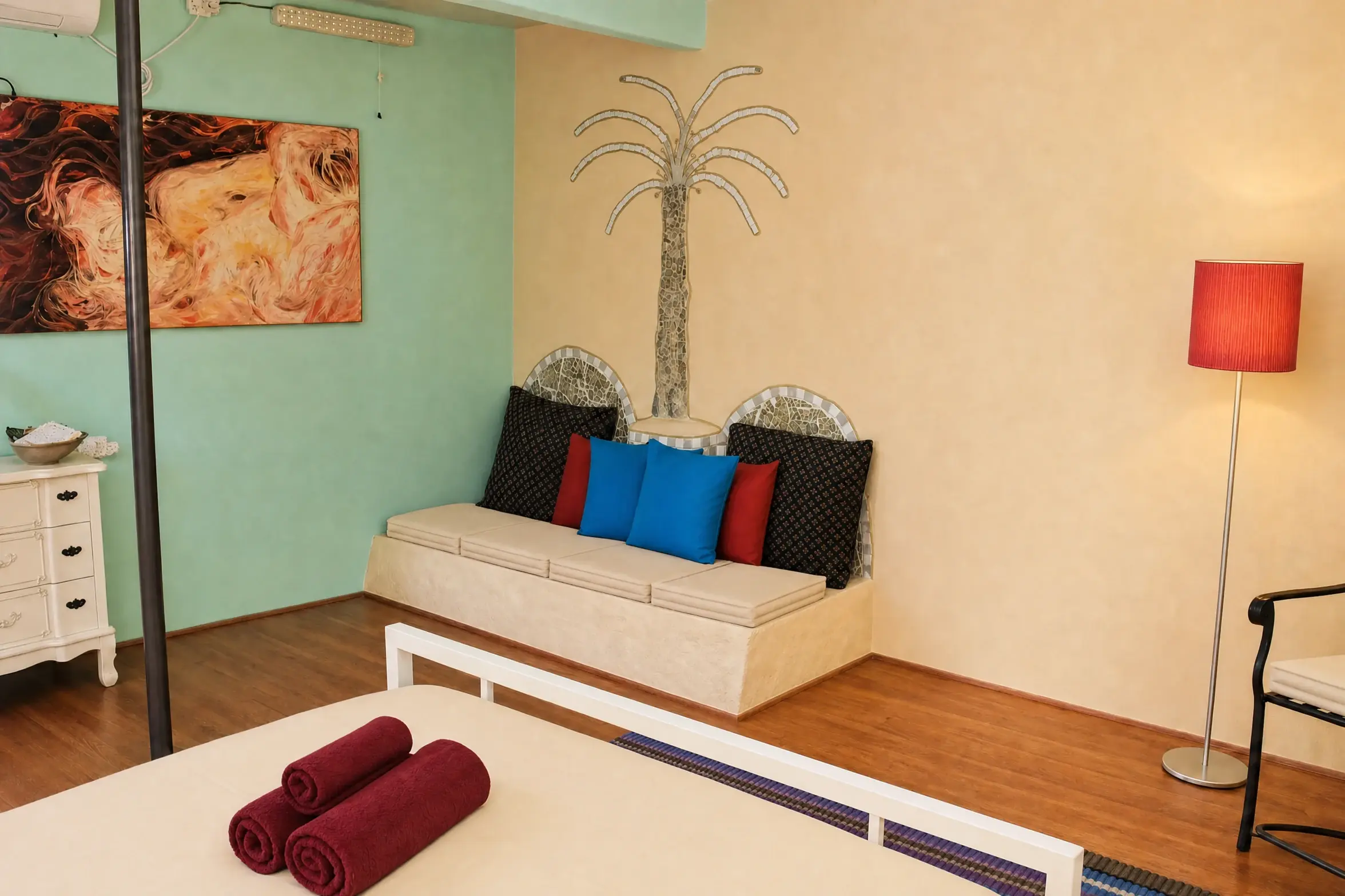 The Triple room: a green wall, a mosaic palm and a red lamp