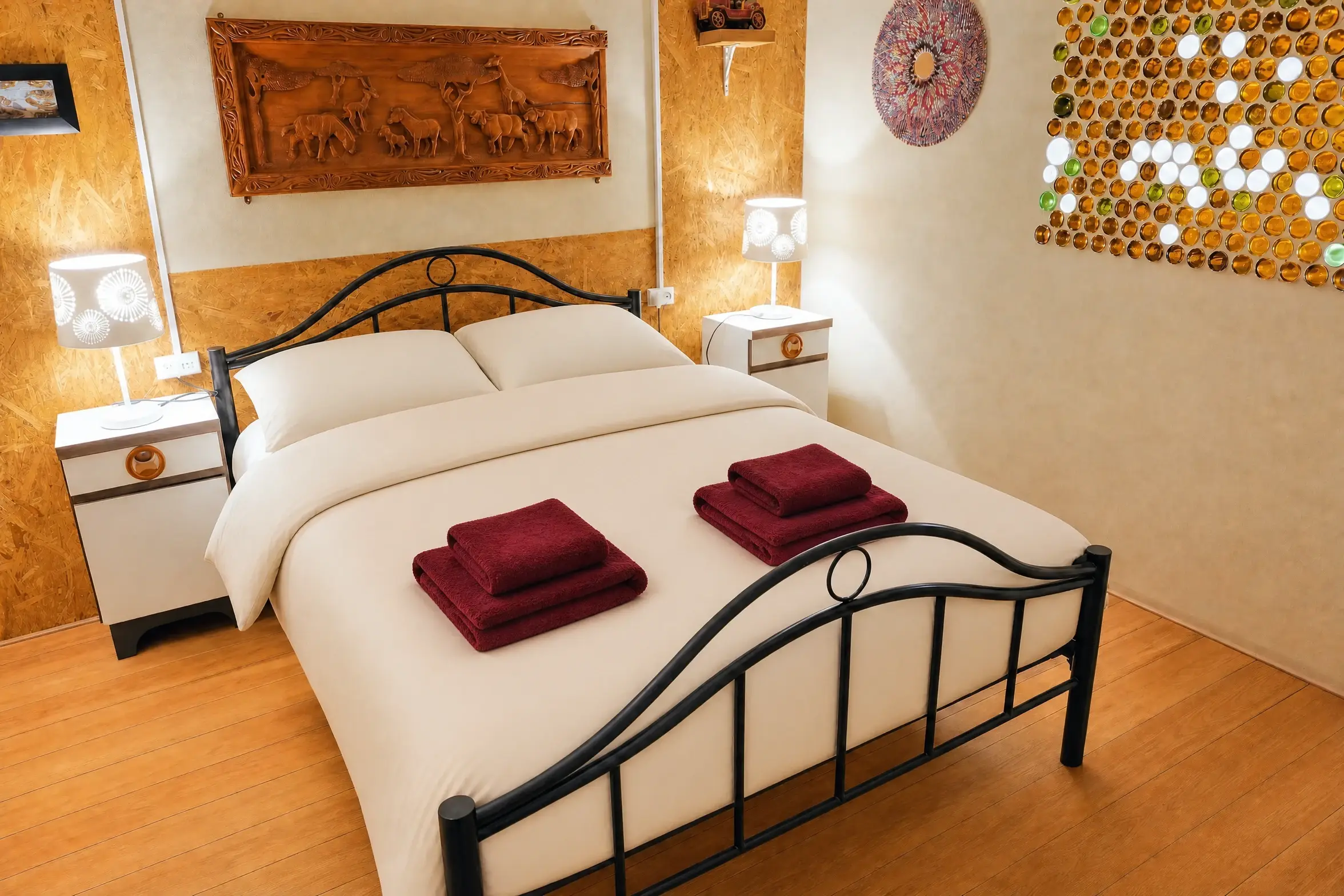 The Vintage room in warm light: the double bed and the carved wooden panel
